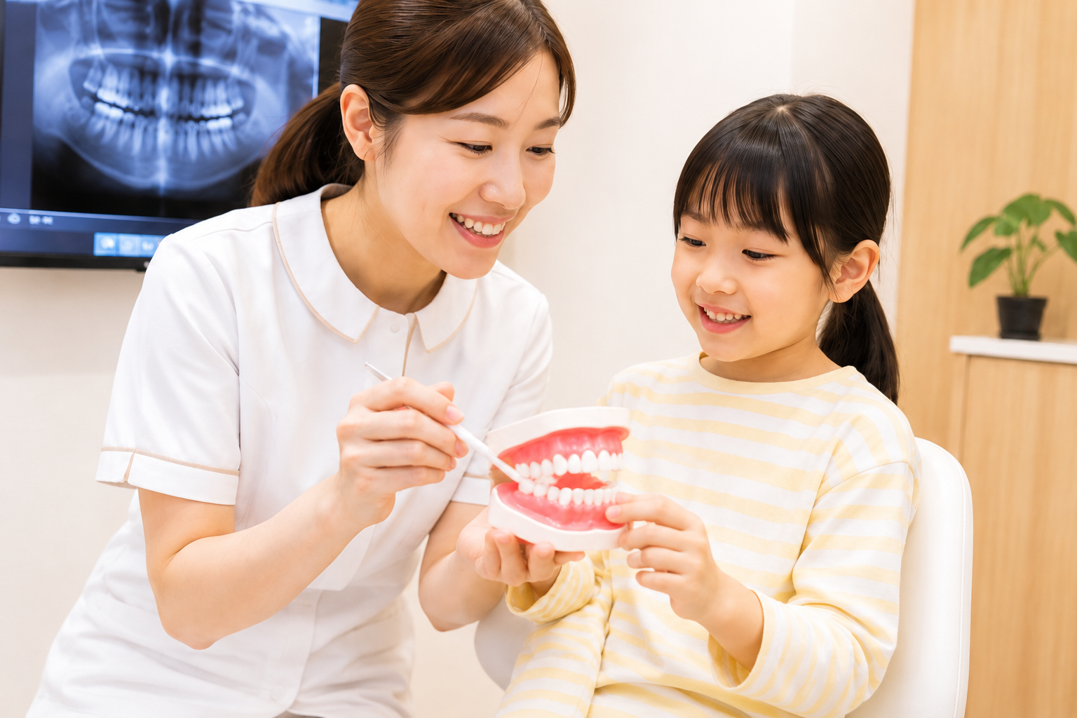 歯科衛生士と一緒に歯の模型で学ぶお子さま